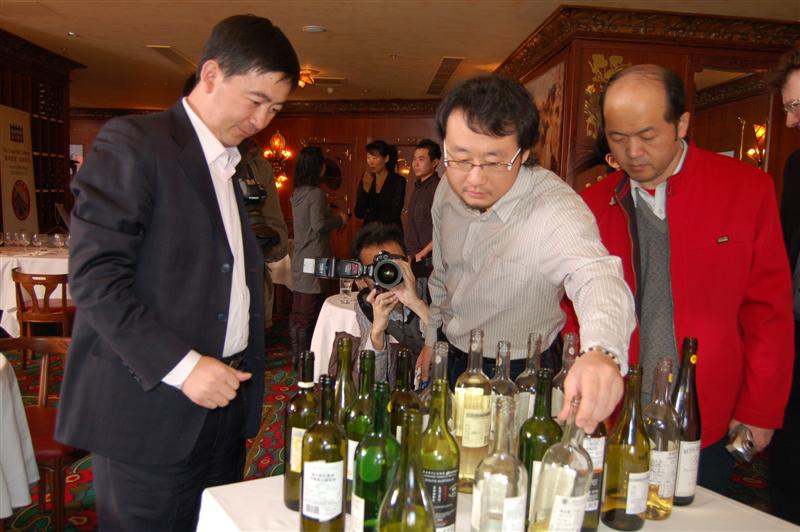 Judges Li Demei, Jin Yang, and Kong Wei Guo check the whites wines after they finish scoring.